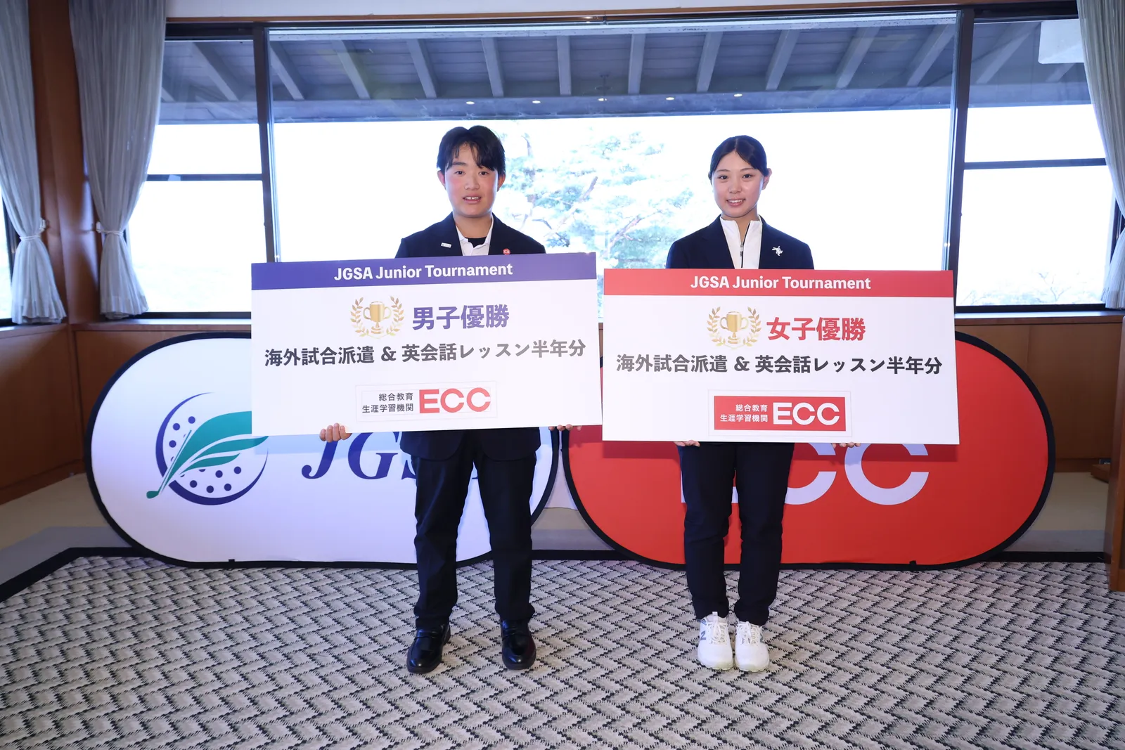 男女優勝者が副賞パネル（海外試合派遣＆英会話レッスン半年分）を持って並ぶ